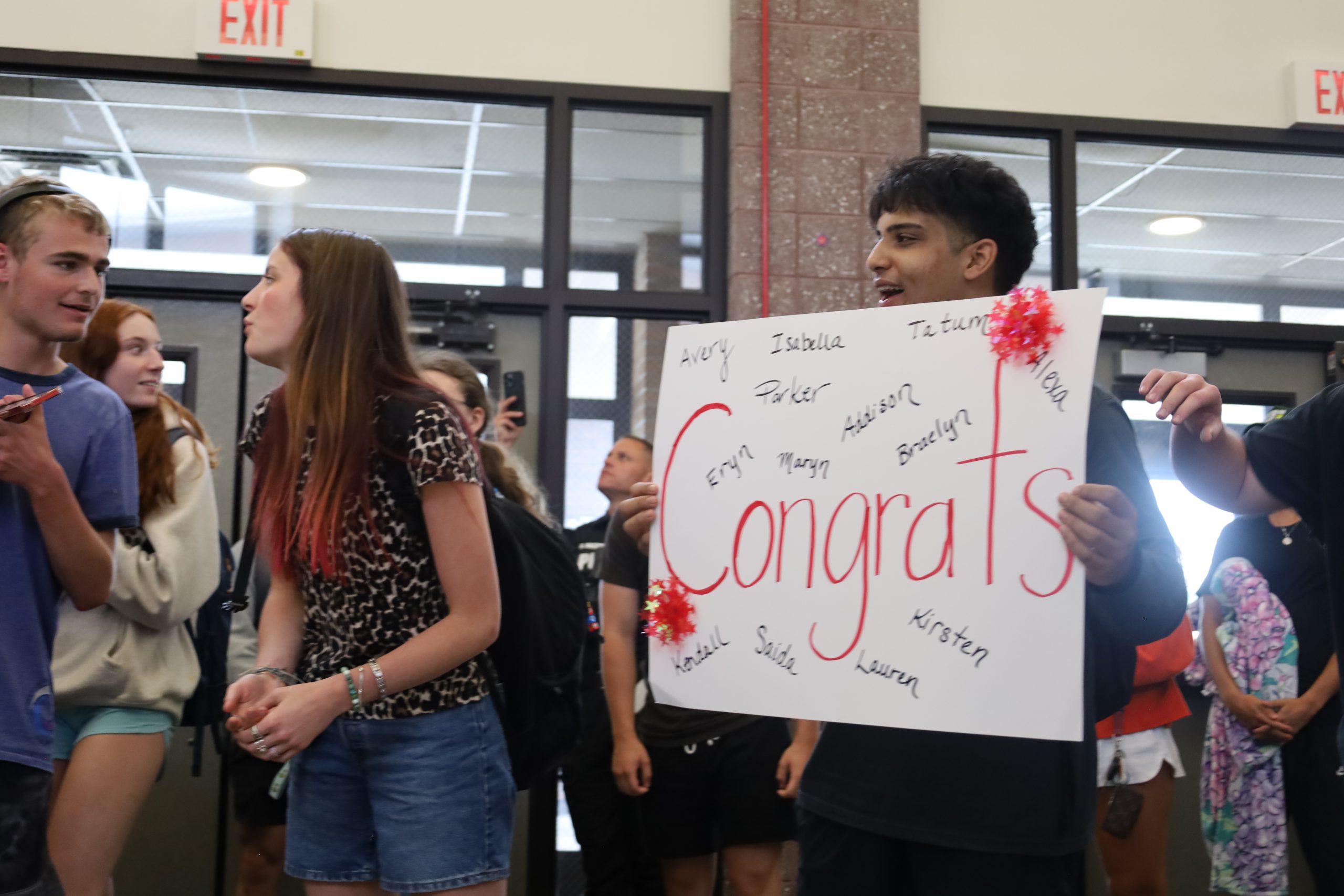 A student holds a sign that reads Congrats
