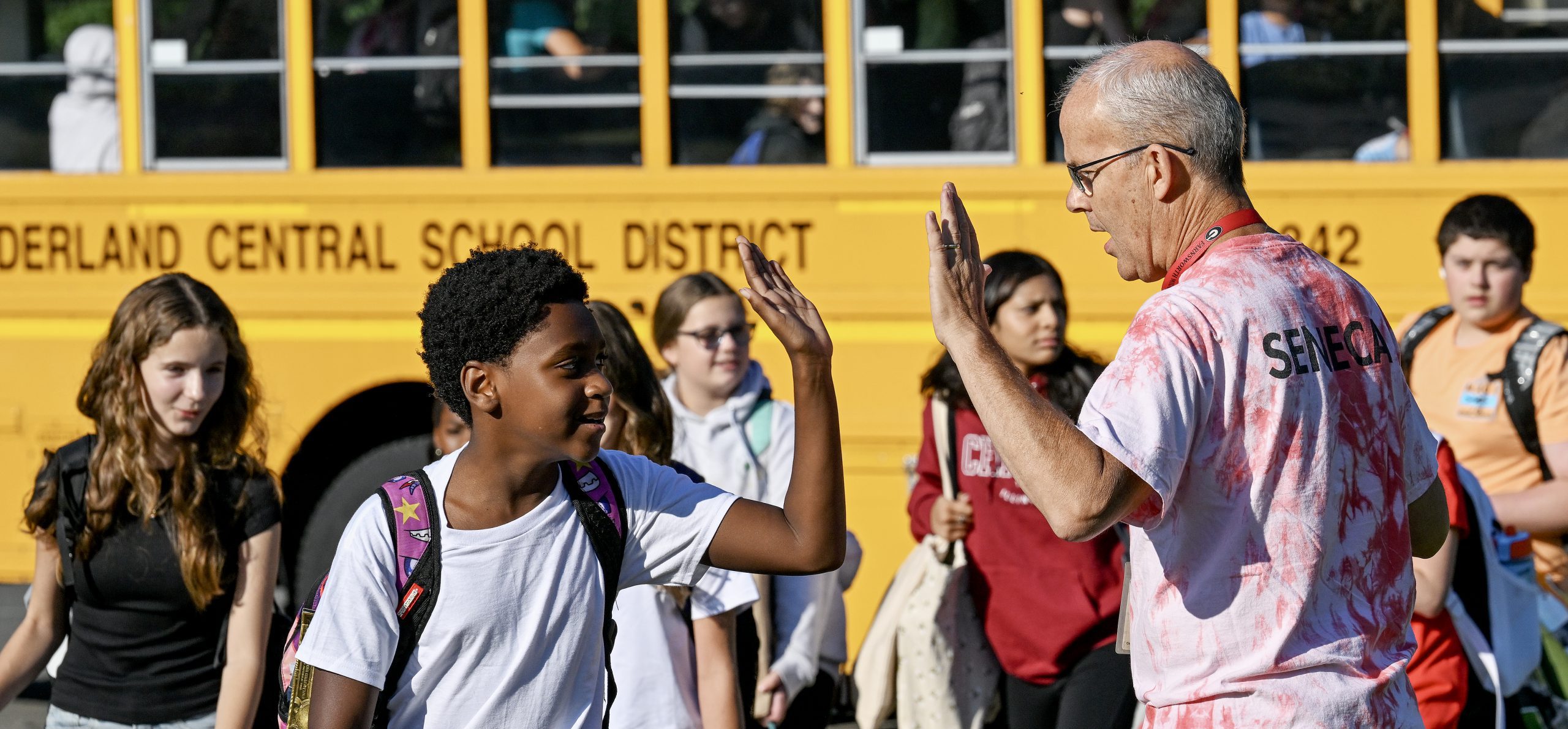 Teacher high fives middle school student on the first day.