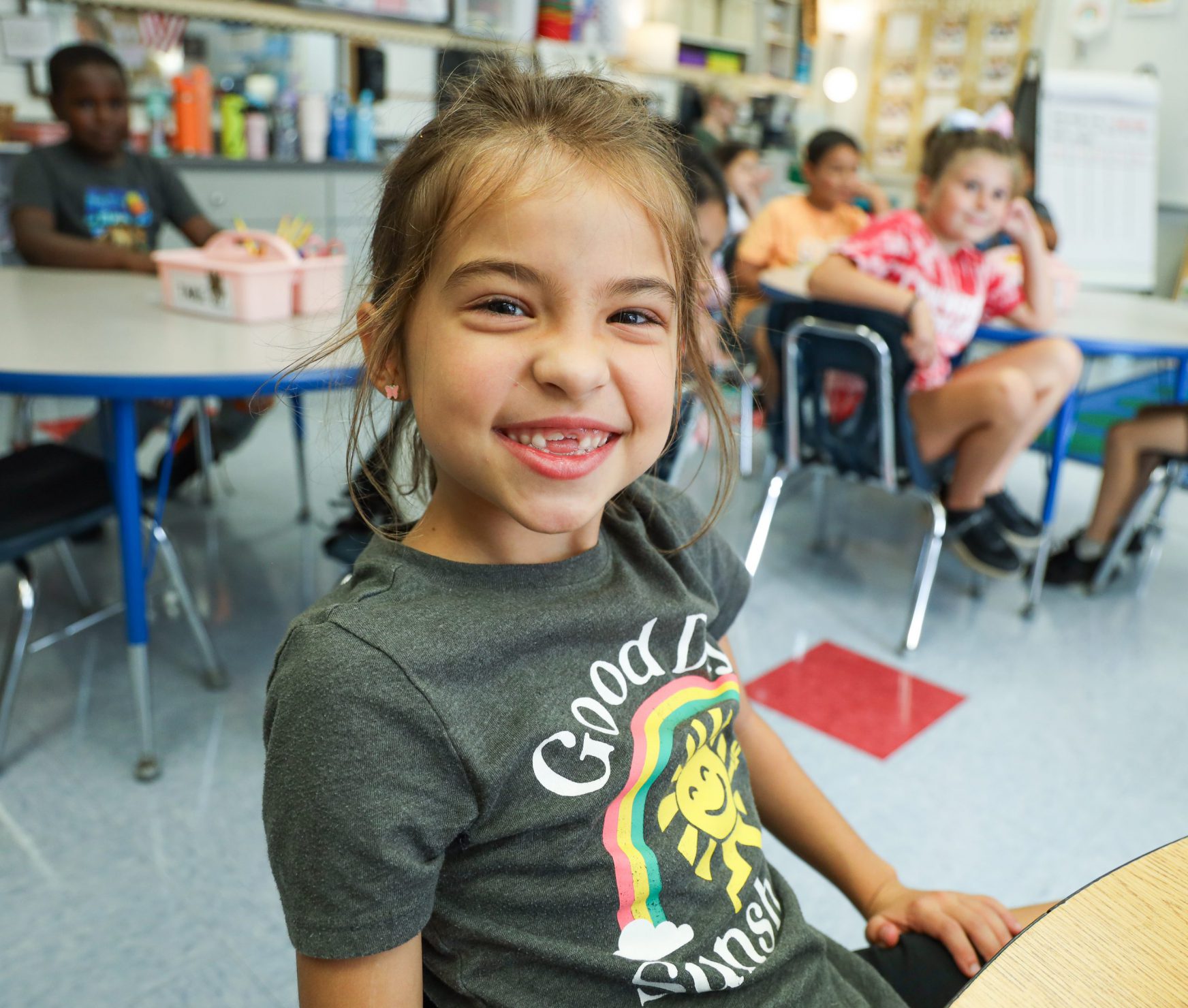 Student smiling while she gets off the school bus on the first day of school.