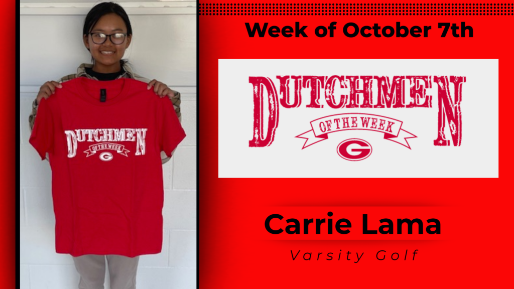 Student smiling and holding a Dutchmen of the Week shirt up for a photo. 