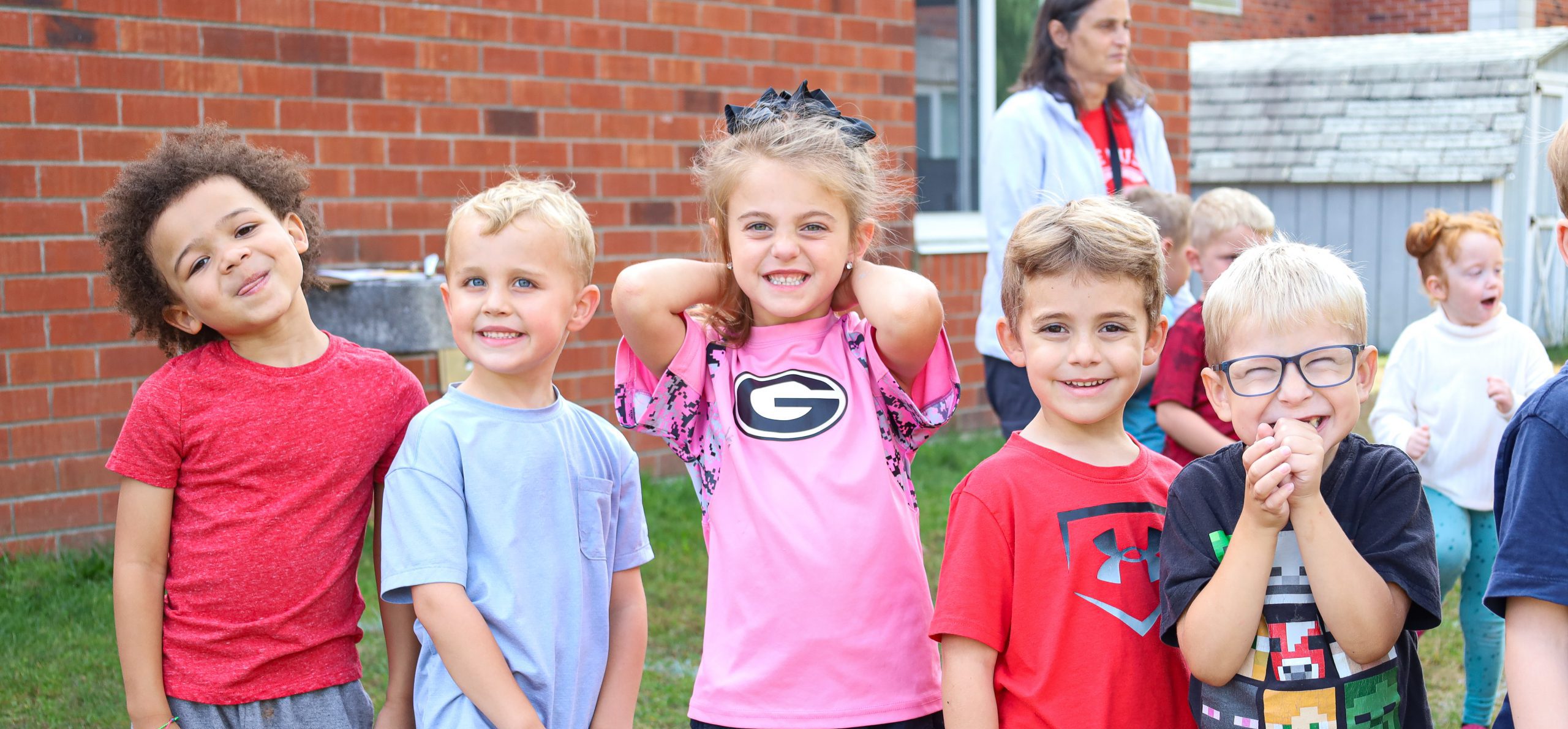 Elementary school students in line smiling for photo at school event.