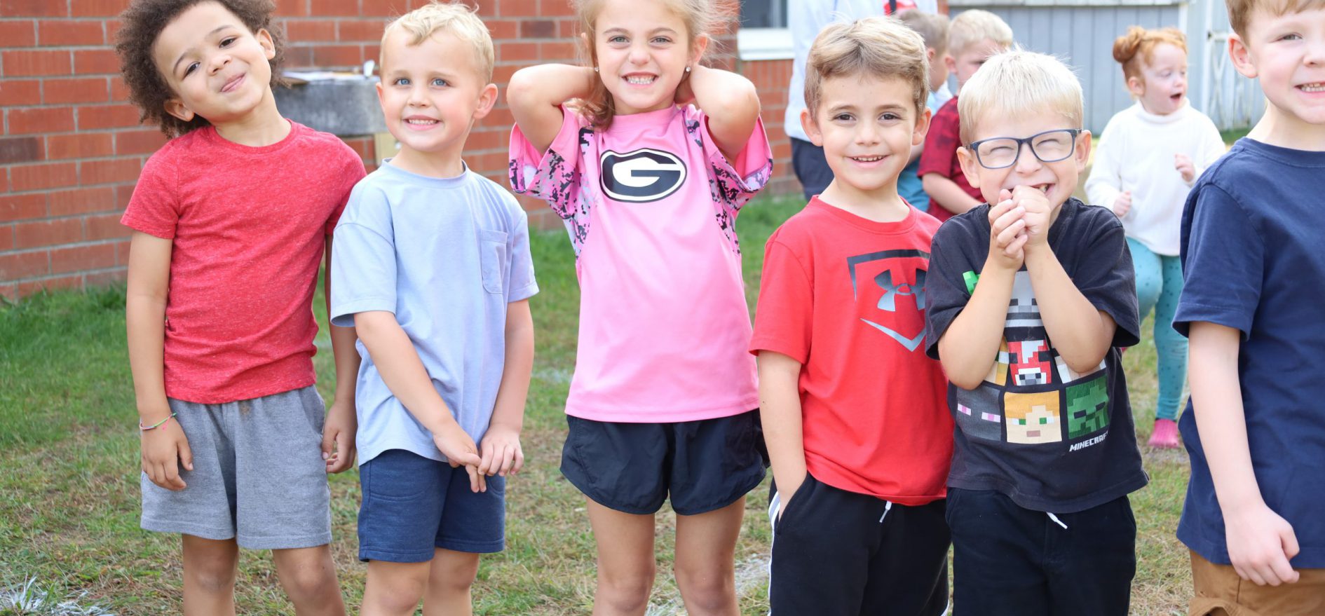 Elementary school students in line smiling for photo at school event.