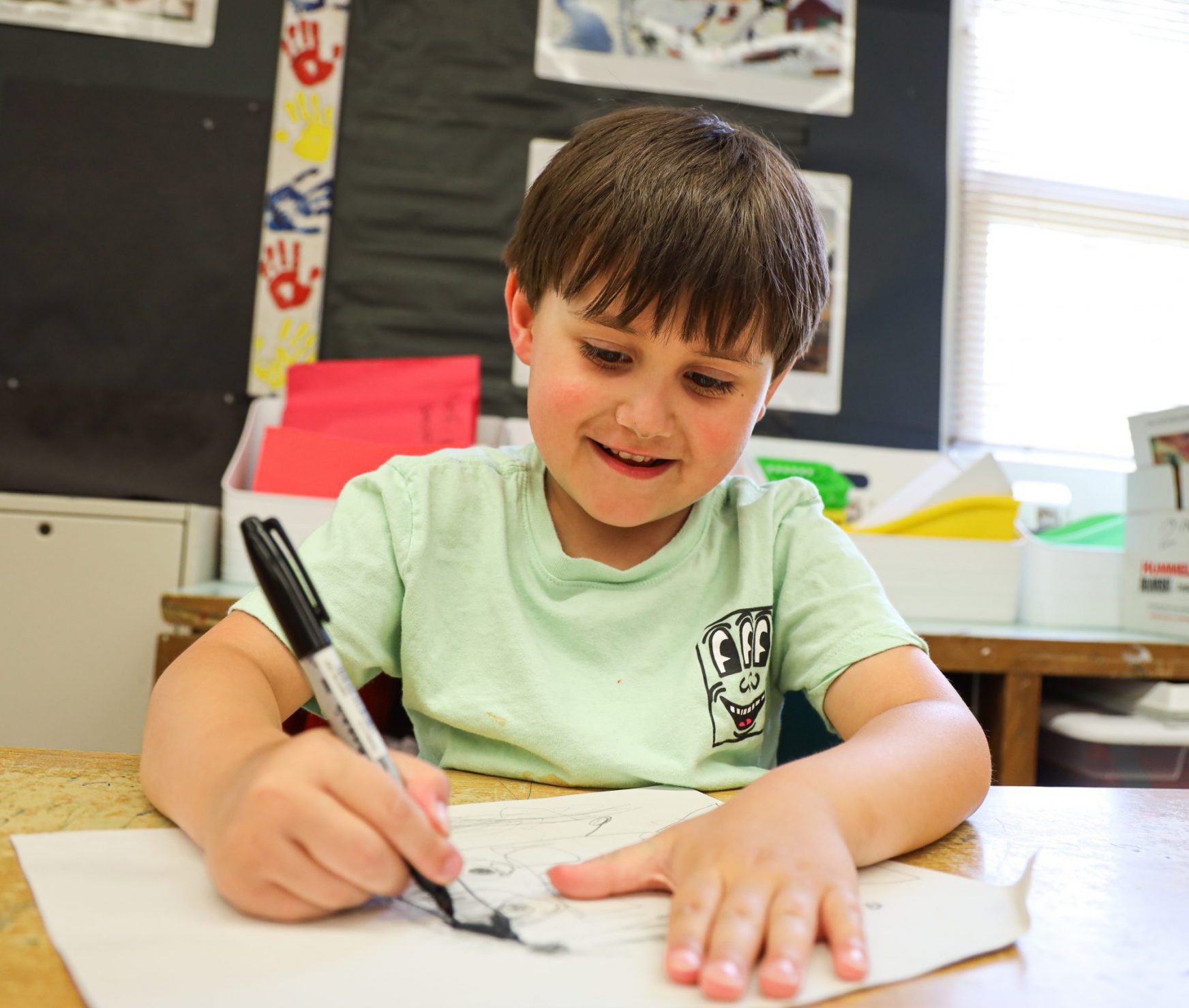 Student smiling while drawing.