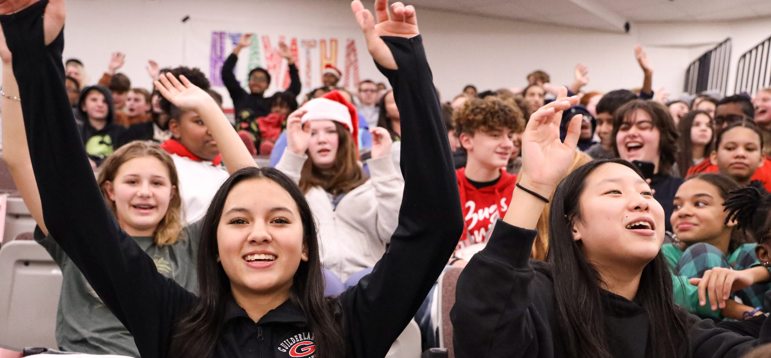 Students cheering at FMS and a student is smiling with both arms up.