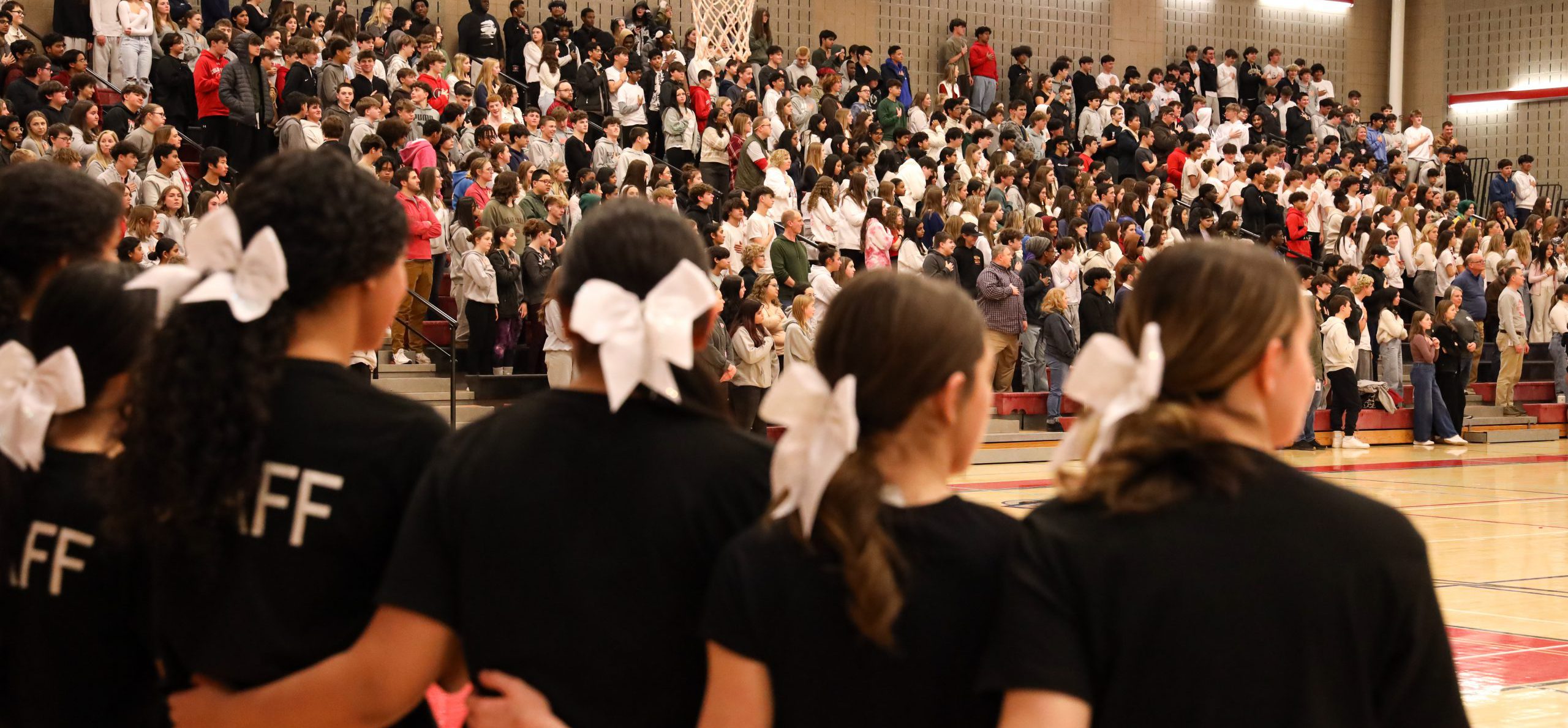 GHS cheerleaders standing together during the Spirit Rally. They are standing arm-in-arm, looking out at the stands.