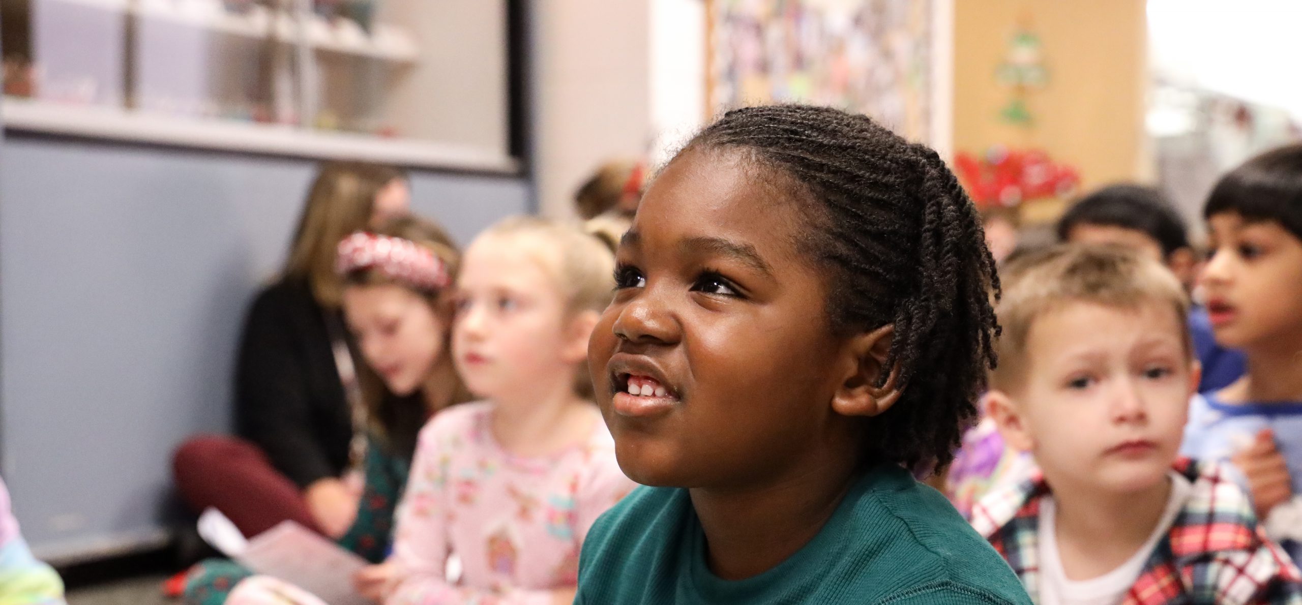 Elementary student smiling during a music sing-along.