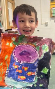 A student is holding a piece of artwork