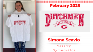 A student stands in front of a white wall, holding a white t-shirt with red lettering that reads "Dutchmen of the Week."