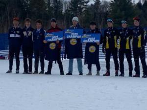 A line of students outside, standing in the snow, holding signs that reads 2025 champions